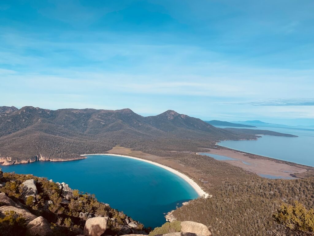blue lake surrounded by mountains under blue sky during daytime